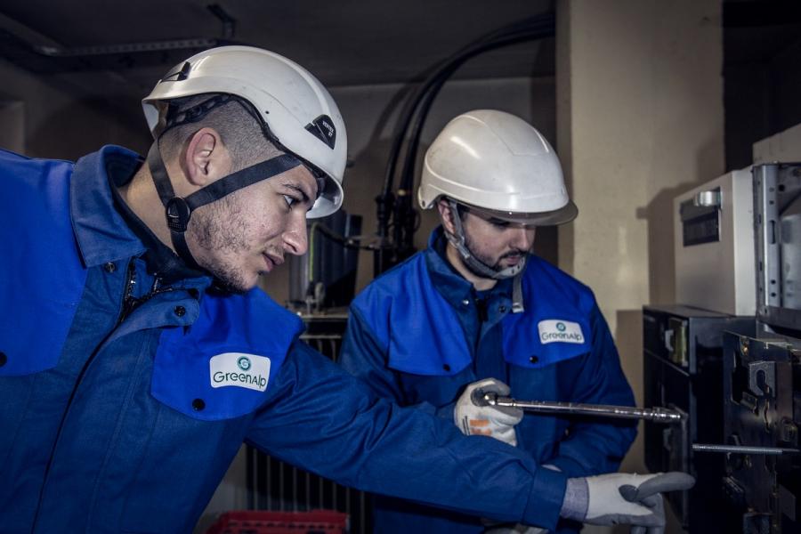 Deux techniciens font de la maintenance sur un panneau électrique